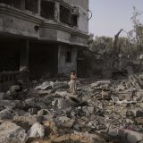Une jeune fille se promène parmi les ruines, à Gaza. KEYSTONE/AP/Abdel Kareem Hana